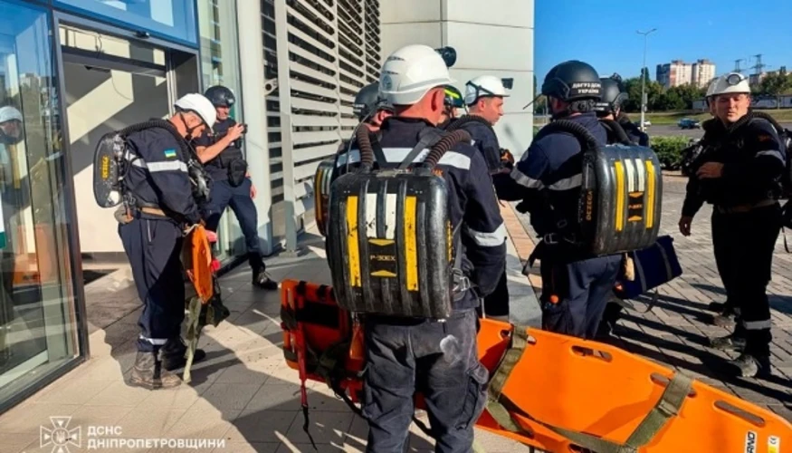Пошкоджена будівля торгового центру, пожежа всередині та рятувальні служби на місці атаки.